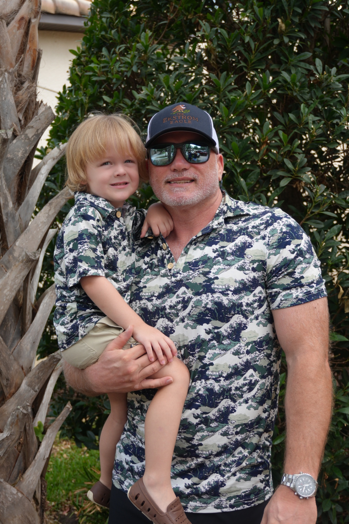 Man and boy wearing matching blue camo Ekstrom Eagle shirts